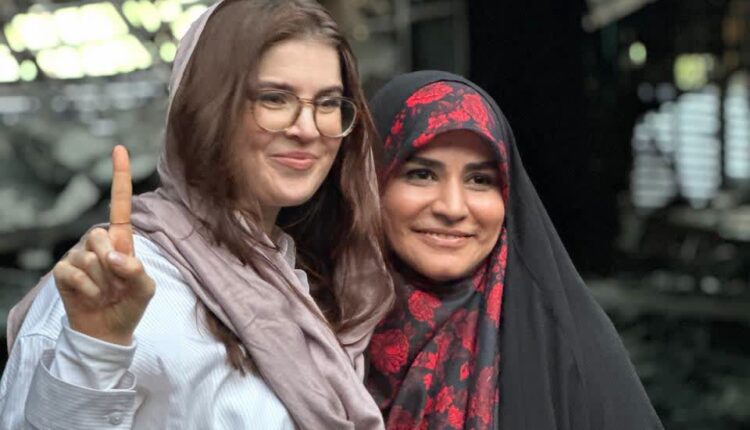 عکس امامی با خبرنگار آمریکایی در کنار ساختمان شیشه‌ای
